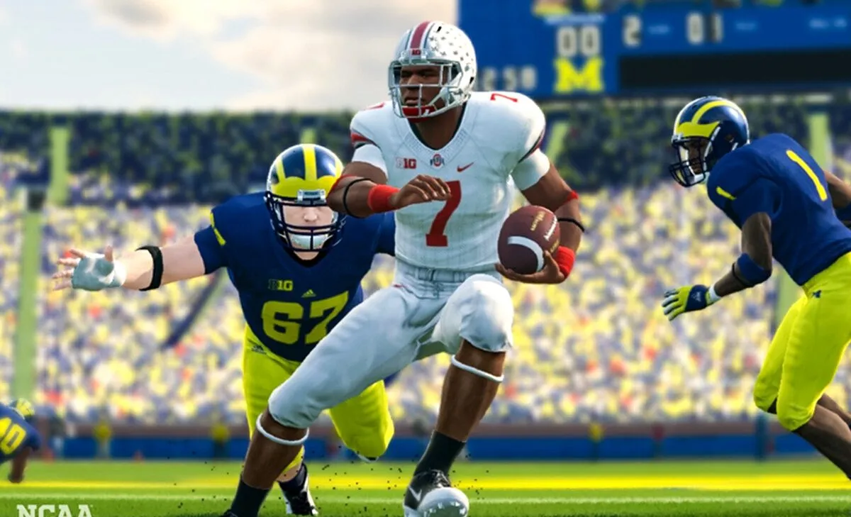A college football player carrying the ball, wearing a white kit. A player in a blue and yellow uniform is trying to tackle him.
